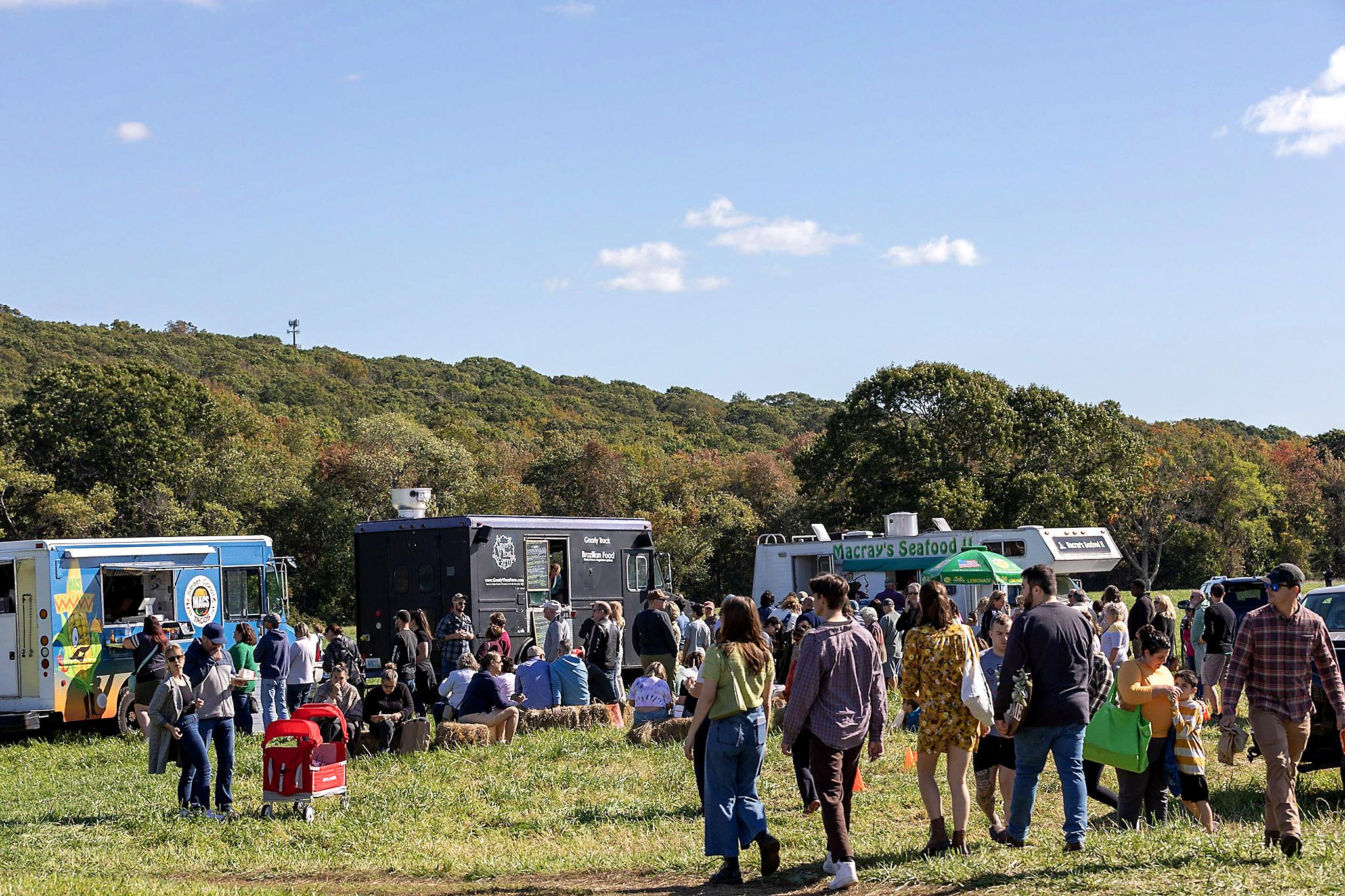 A field with food trucks and a crowd of people